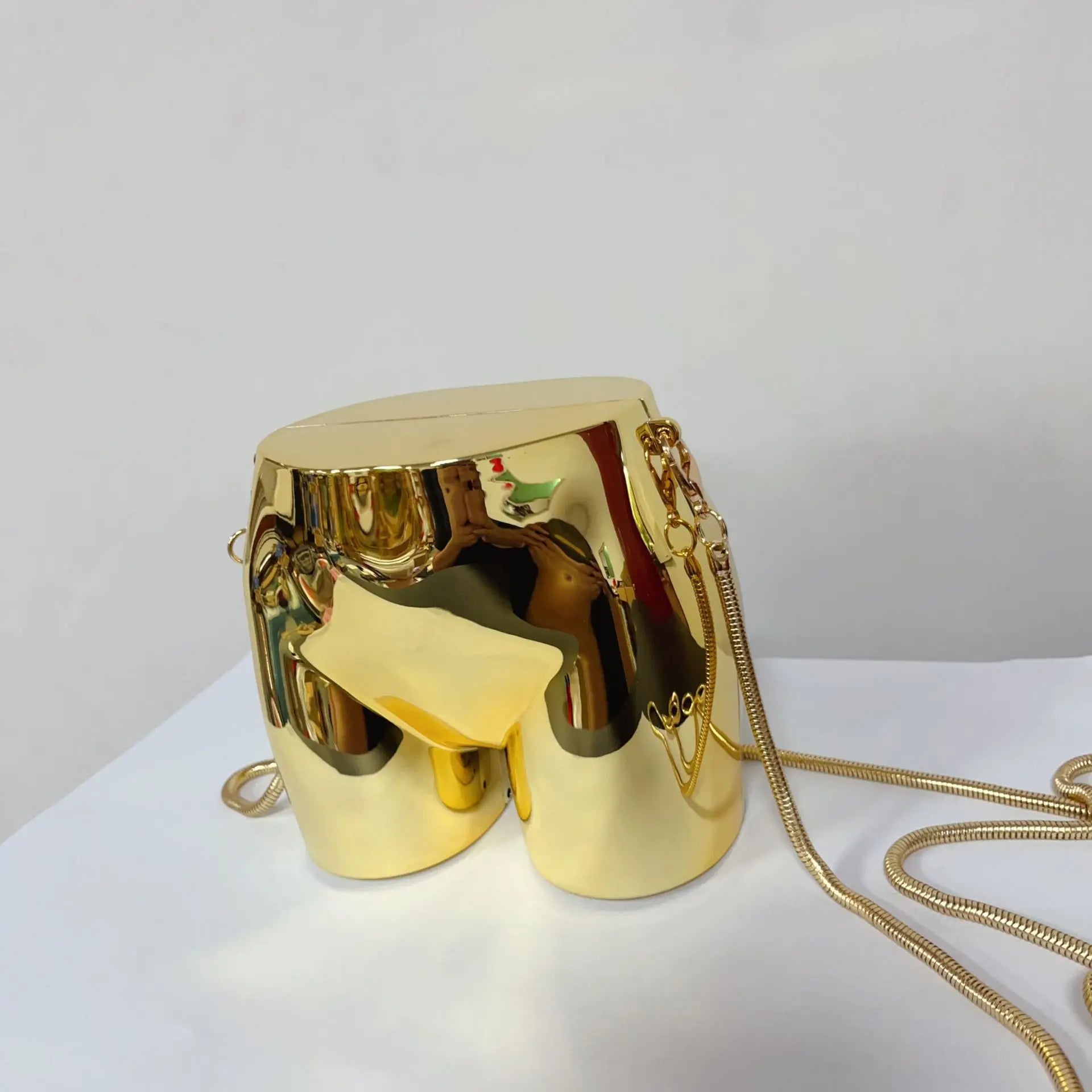 Clutch purse with chain strap in a sleek gold design, perfect for evening events and parties.